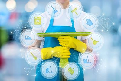 Cleaner holding a mop and displaying all the janitorial tasks