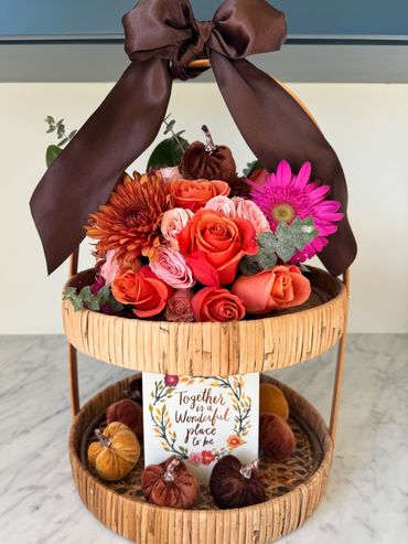 Two-tier basket with flowers, velvet pumpkins, and a card with a heartfelt message.