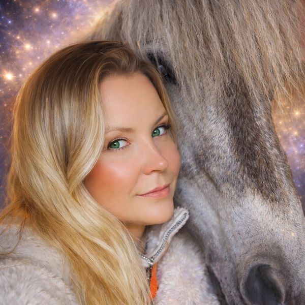 A woman with green eyes close to a horse.