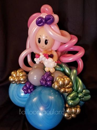 Pink-haired balloon mermaid with shells and ocean theme. Balloon sculpture.