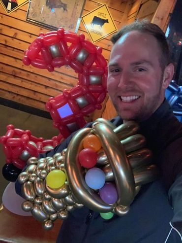 Kids of all ages love balloons. Handsome guy with superhero balloons. Birthday delivery sculptures.