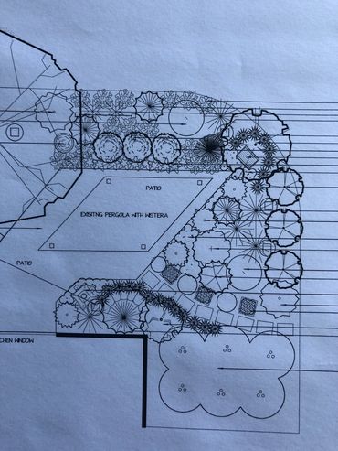 A large front garden area with a large seating area and a very architectural pergola designed by the