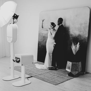 black and white image of wedding couple using photobooth