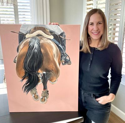 Woman standing next to a painting of a jumping horse.