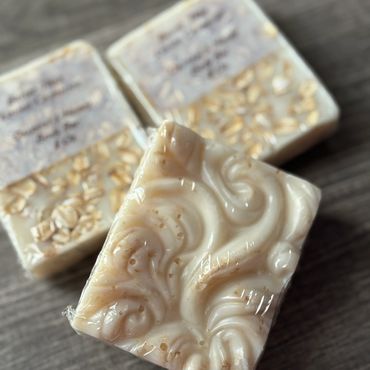 Close-up of intricately designed soap bars with oats on a wooden surface.