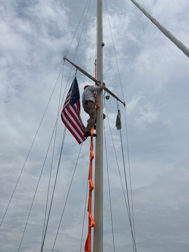 American flag flying from a sailboat mast, veteran-owned marine surveyor No Salt Surveyor