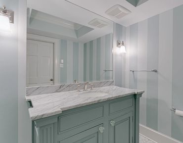 Custom powder bathroom with custom vanity and elegant striped walls.