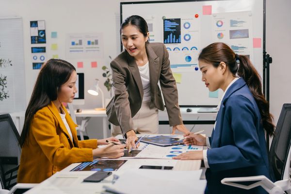 Three young asian businesswomen are meeting in a modern office
