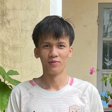 Young man posing outdoors with a slight smile.