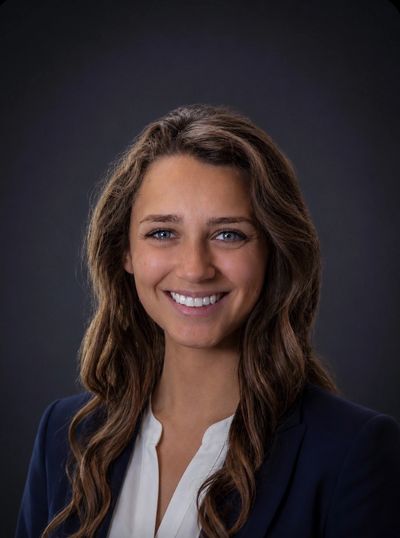 Smiling woman with long hair in business attire.