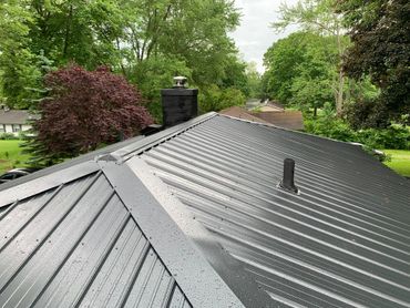 New steel roofers working on durable metal roofing system
