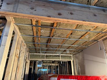 Ceiling insulation and framing in a building under construction.