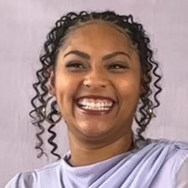 Woman with curly hair laughing joyfully.