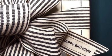 Black and white striped ribbon tied in a bow with 'Happy Birthday' text.