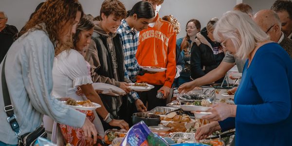 People serving themselves food at a buffet.