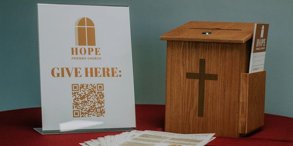 Donation setup at Hope Friends Church with QR code and wooden box.