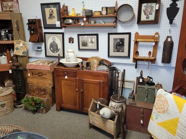A vintage room with antique furniture, old photographs, and rustic household items.