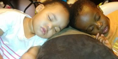 Two toddlers sleeping peacefully side by side.