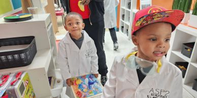 Two children in white lab coats exploring.