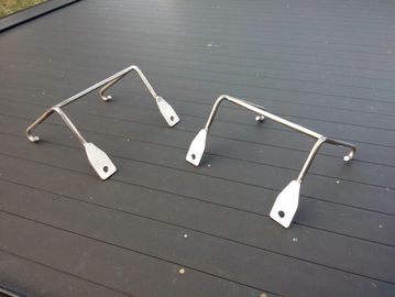 Two metallic brackets on a black surface.