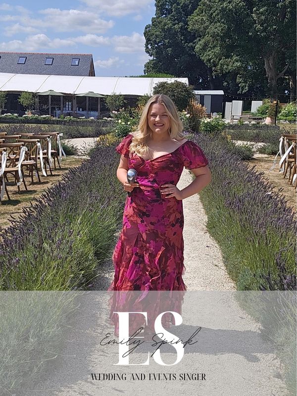 Wedding and events singer Emily Spink in a vibrant floral dress outdoors.
