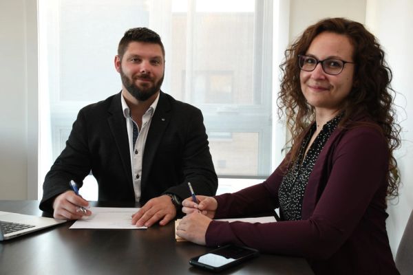 Deux collègues signant des documents au bureau.