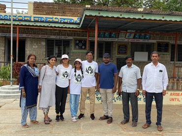 Group of people (the founders and volunteers) standing in front of a high school in India