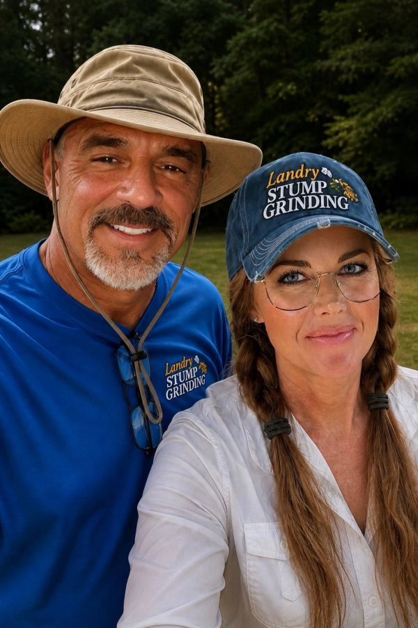 Gary & Tonya Landry wearing Landry Stump Grinding hats and shirts outdoors.