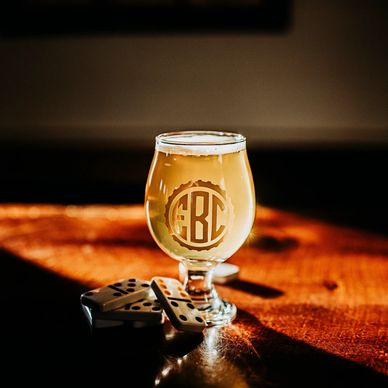 A photo of a light-bodied beer with dominos around the glass.