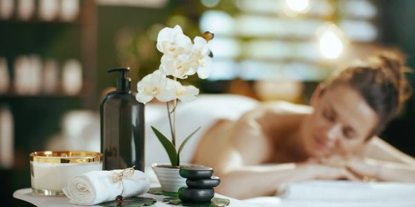 Relaxing spa scene with a woman and aromatic setup.