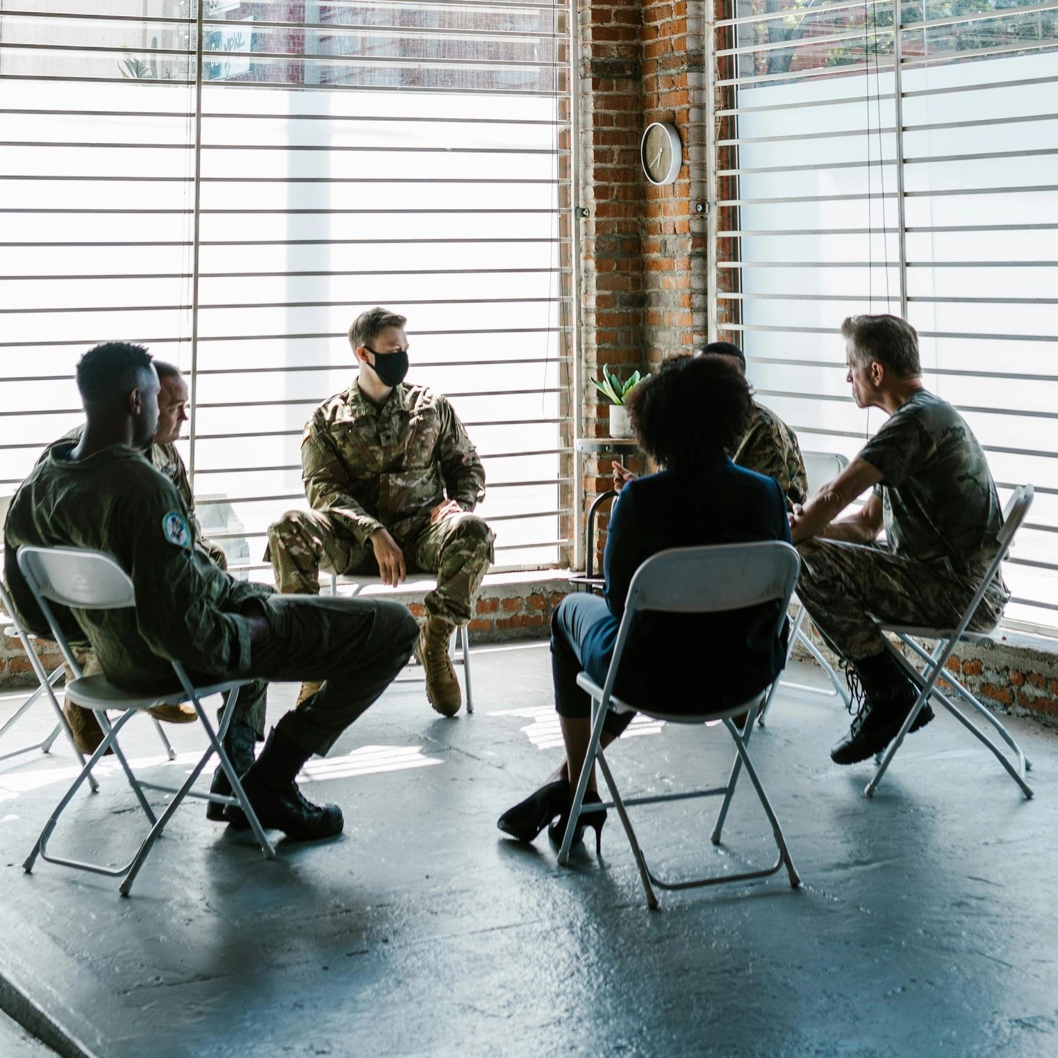 Group of veterans in uniform having a PTSD Mental health and grief discussion