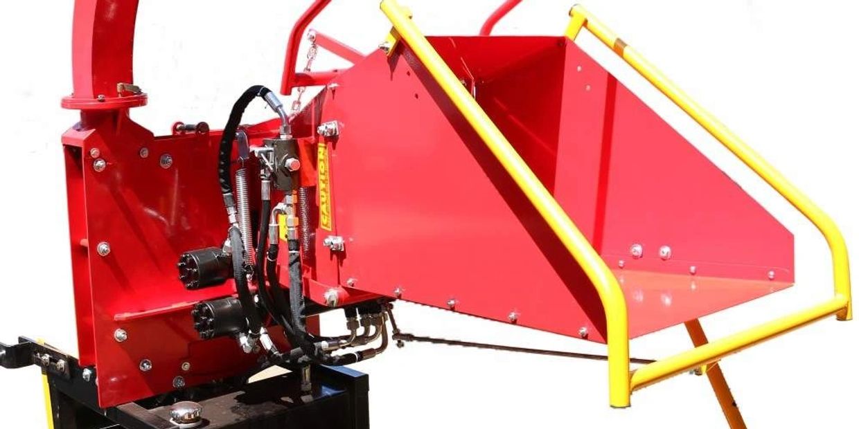 Close-up of a red agricultural machine with yellow safety handles.