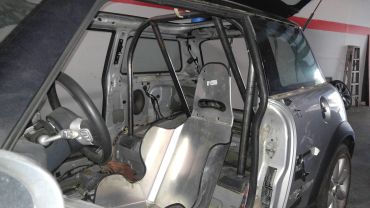 Interior view of a stripped-down racing car with a roll cage.