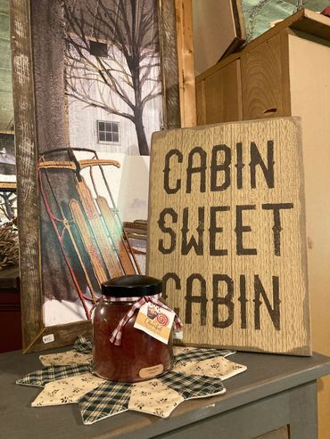 American made home decorations with a candle, picture, and sign.