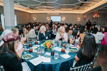 A wide pan of the attendees sitting at tables during the luncheon.