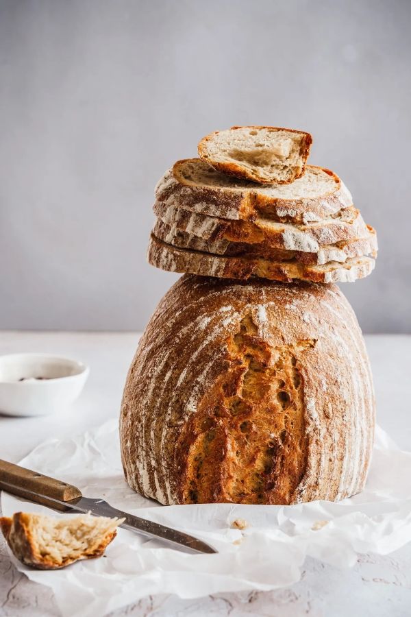 Rustic sourdough bread with slices on top.