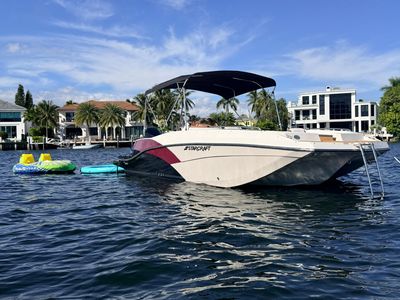 Starcraft boat anchored near waterfront homes on a sunny day.