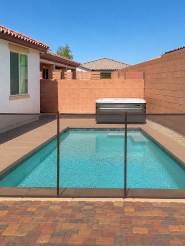 Removable mesh pool safety fence protecting a rectangular backyard swimming pool and spa in Las Vega