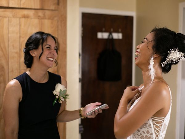 Two women laughing and sharing a joyful moment indoors.