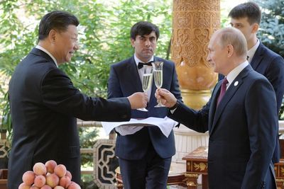 Russian President Vladimir Putin toasts with Chinese President Xi Jinping