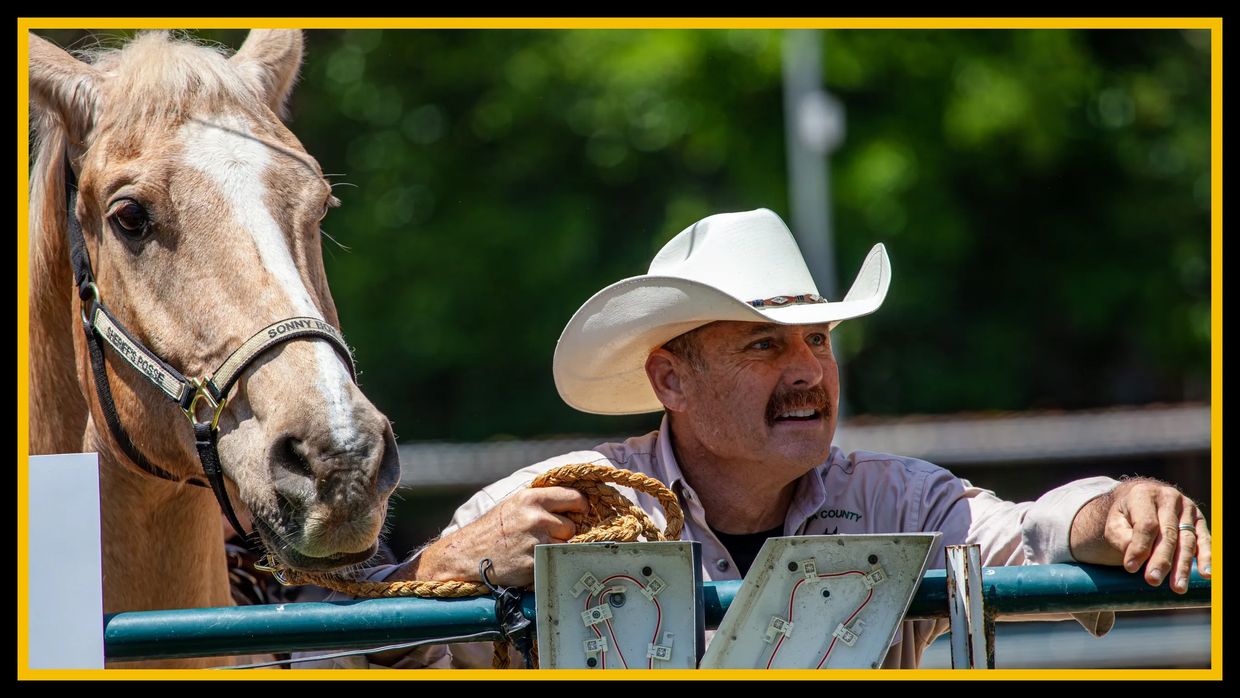 Man in cowboy hat with his horse.