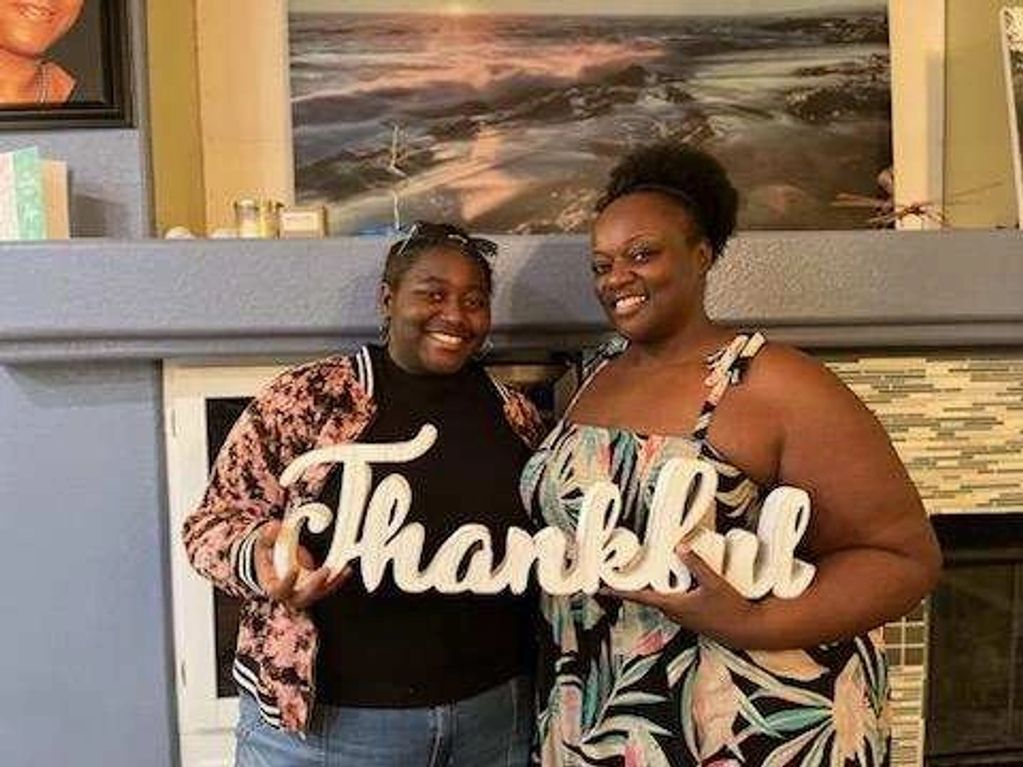 Proud mother with her daughter holding a thankful sign as sign of gratitude.