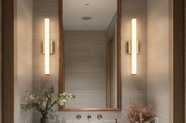 Modern bathroom vanity with round sink, tall mirror, and warm lighting.