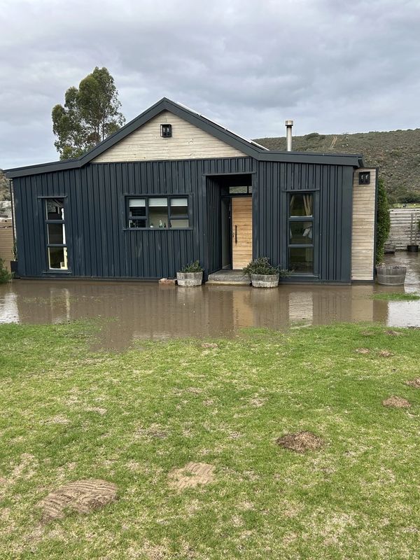 Small modern house partially flooded with muddy water.