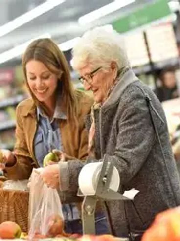 Two women shopping for fruits in a grocery store.