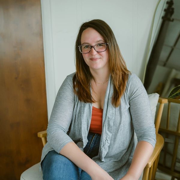 Woman sitting on a chair smiling.