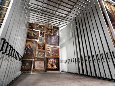 Art storage room with paintings on movable panels.