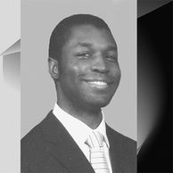 Professional portrait of a smiling man in a suit and tie.