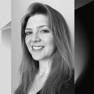 Smiling woman with long hair in a black and white portrait.