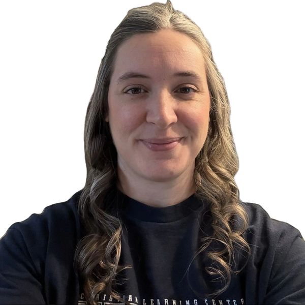 Woman with long curled hair smiling at the camera against a white background.